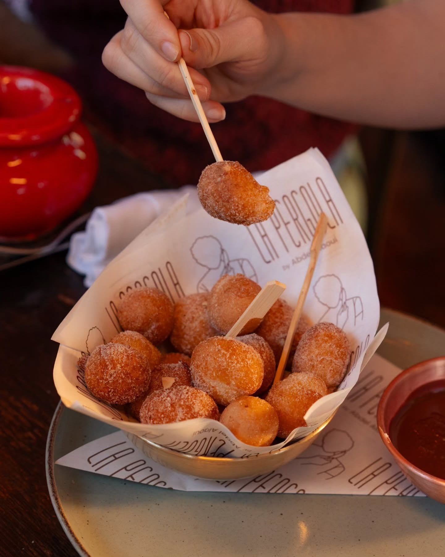 Sugared doughnut bites with a chocolate dip, served in La Pergola paper