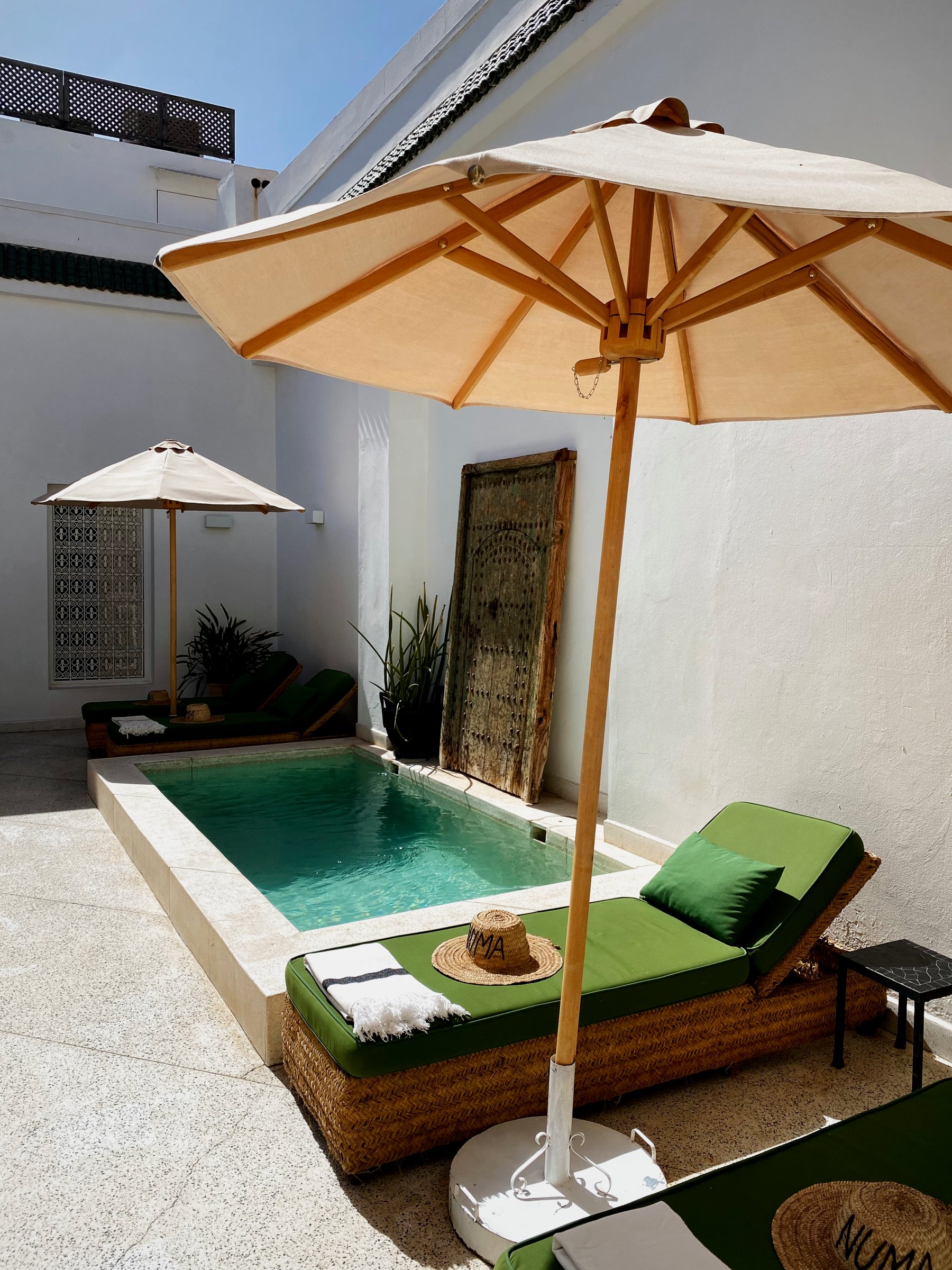 The plunge pool at Numa with a green sun lounger under a parasol