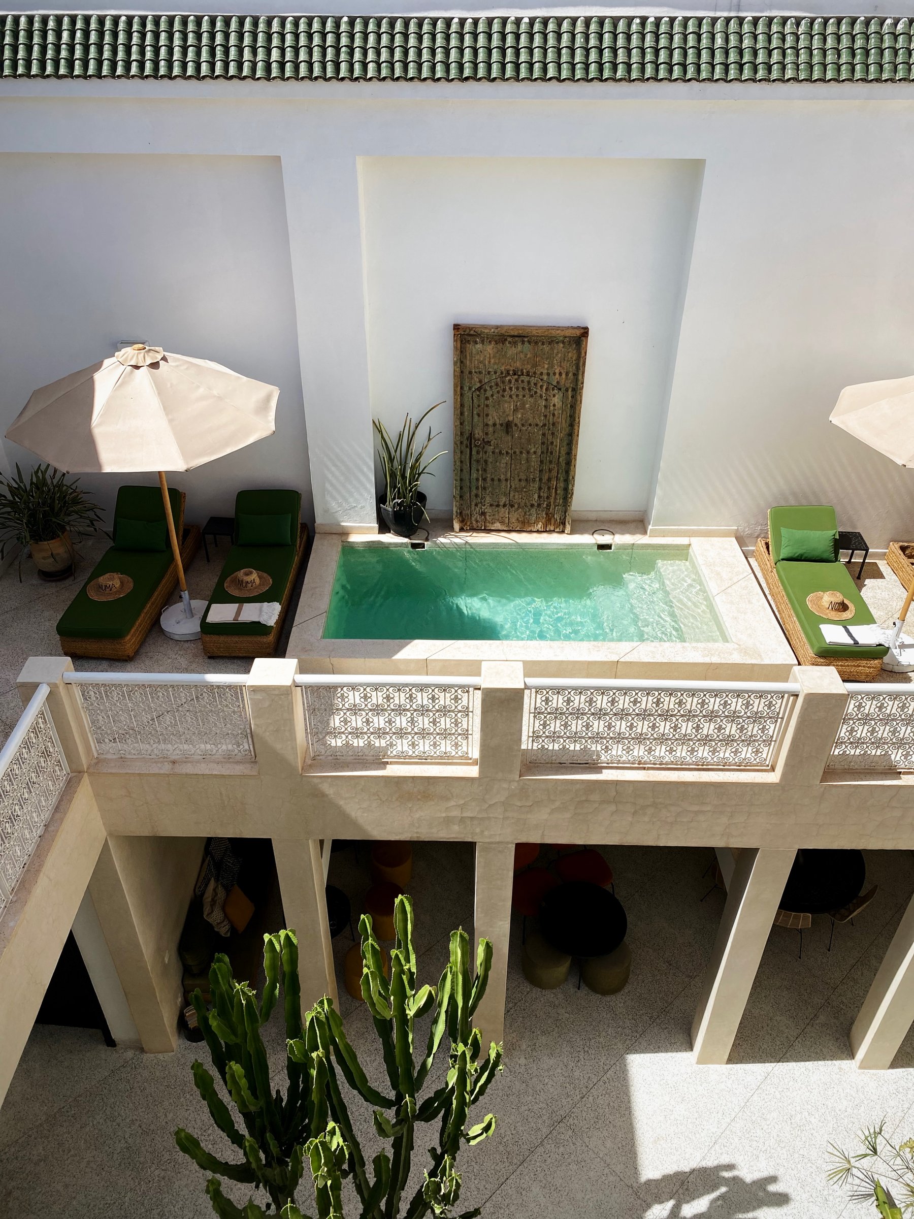 The plunge pool at Numa seen from the gallery above, with loungers and parasols