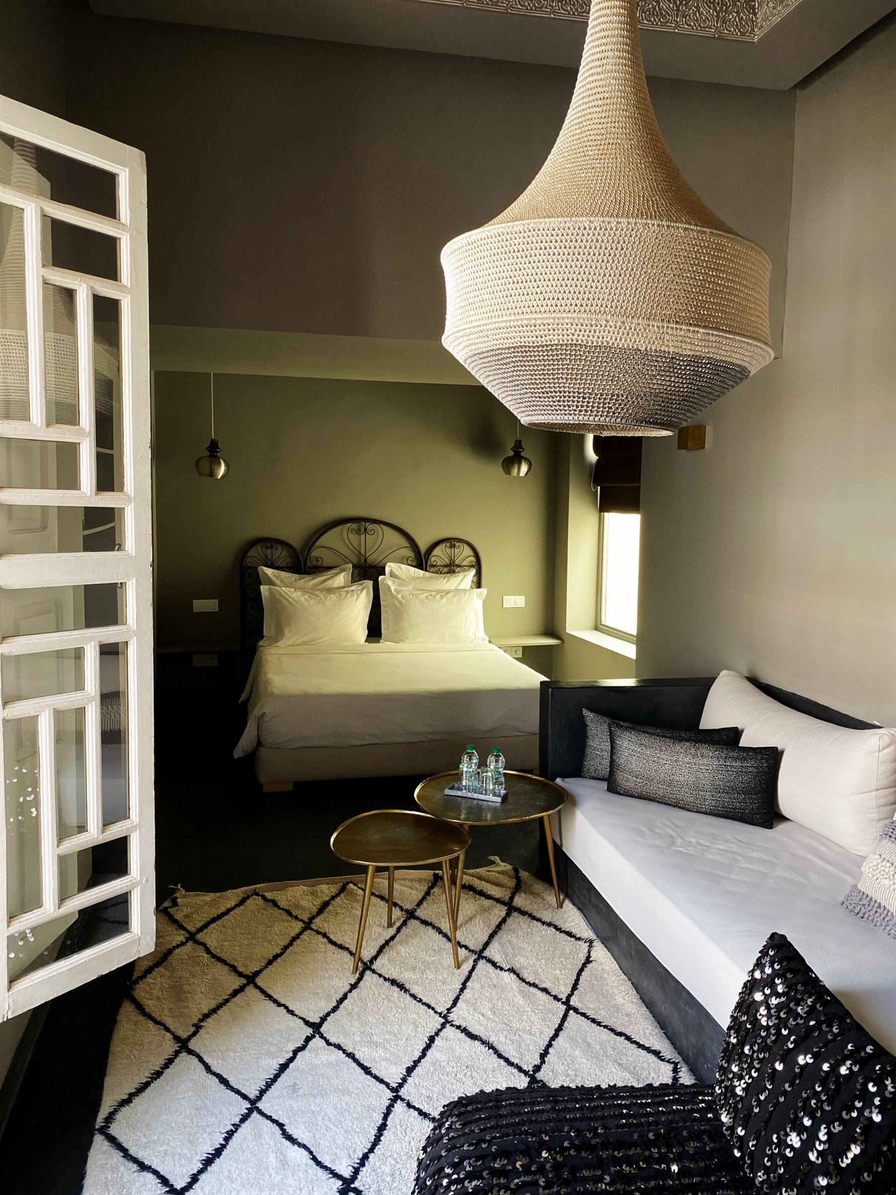 A suite at Numa with a woven pendant lamp, a Berber rug and a daybed