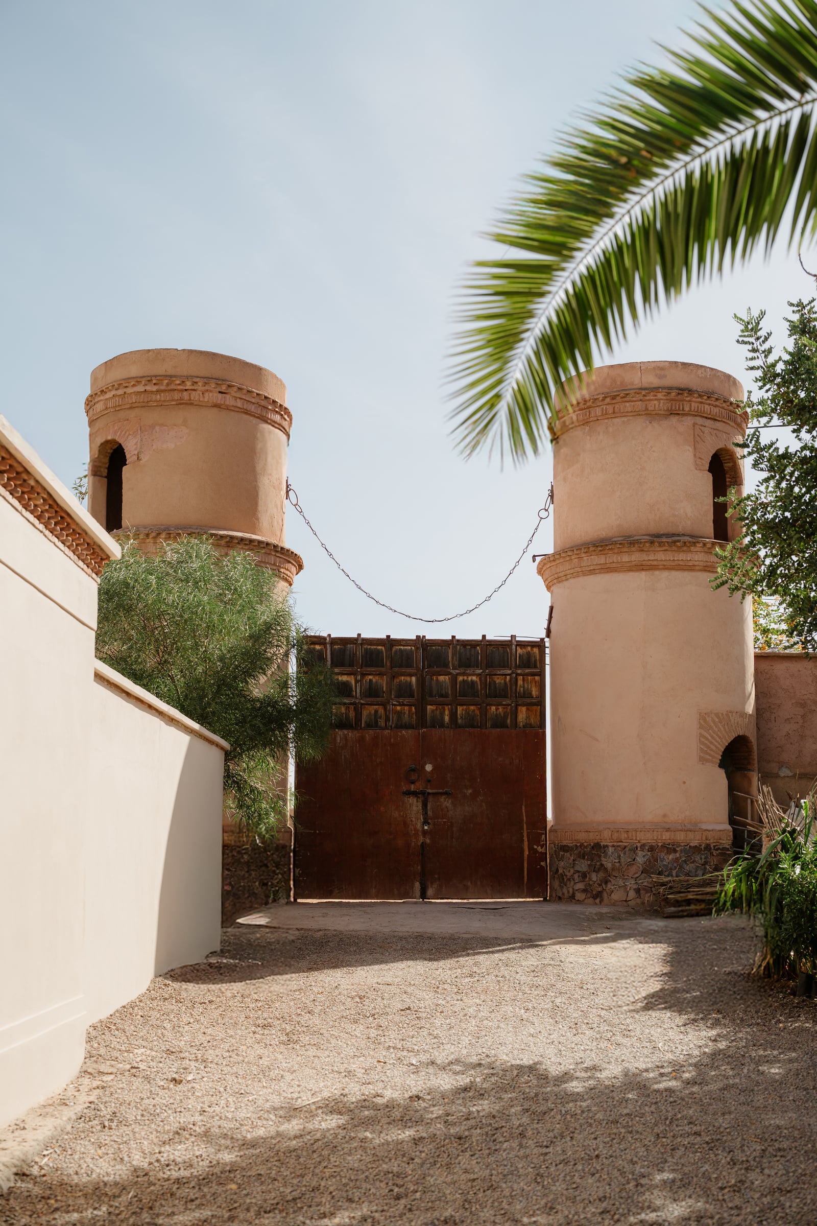 The hotel's twin rounded towers with brick cornices, joined by an iron chain above the dark wooden gate.