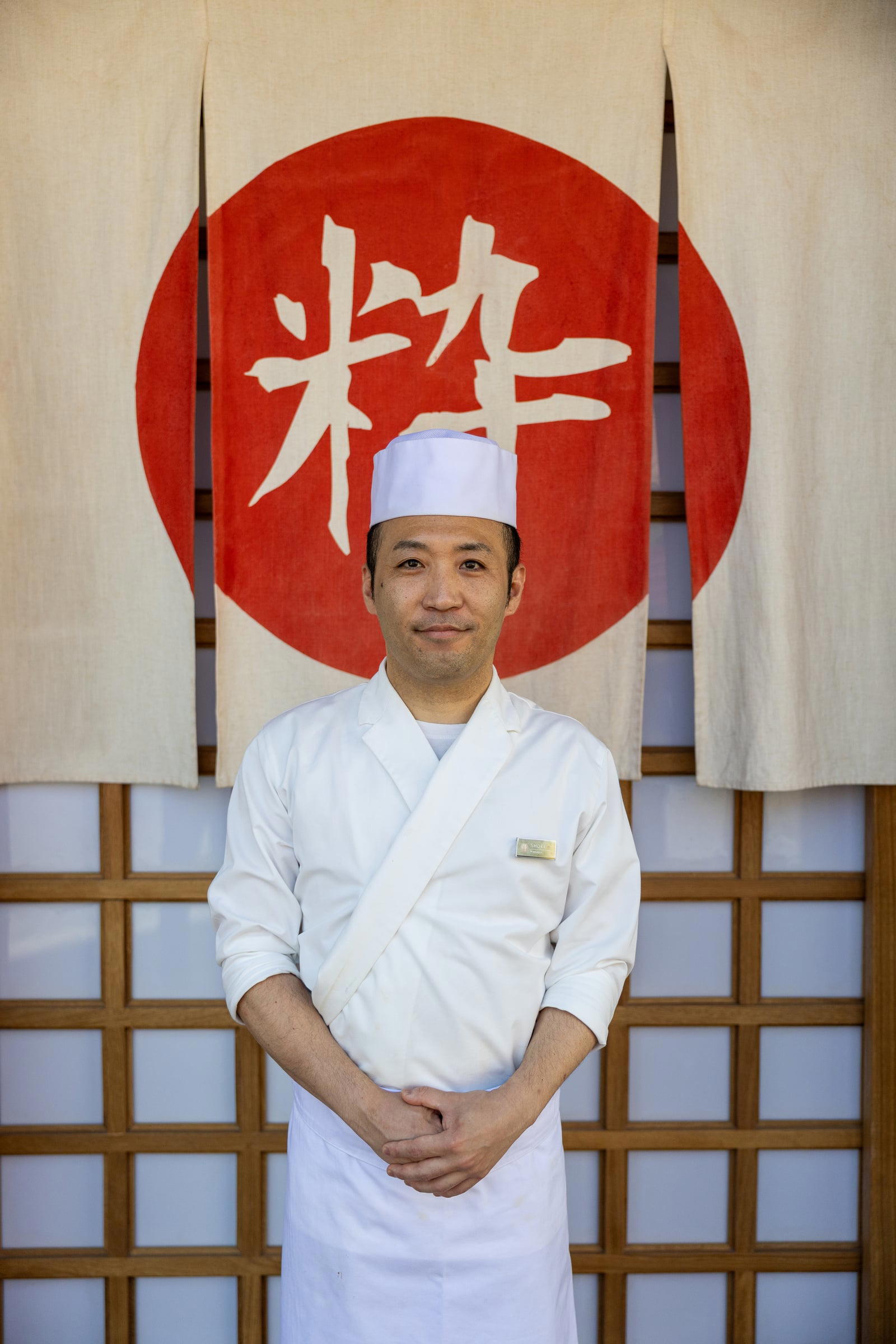 Chef Shoki Yokoyama in front of the noren bearing the kanji for iki. Credit Joanne Poinsignon