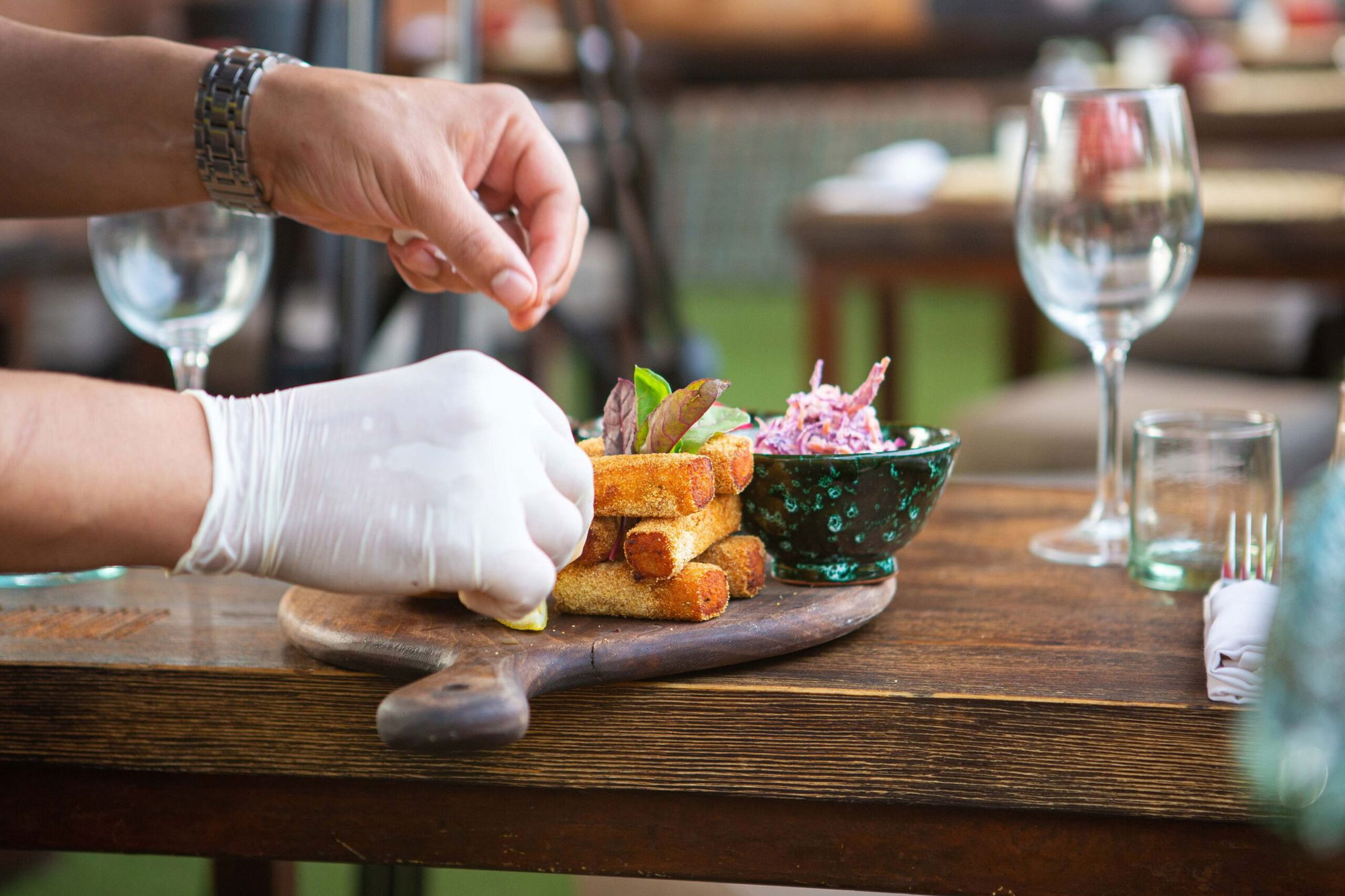 A cook finishing a plate of starters on a La Pergola table