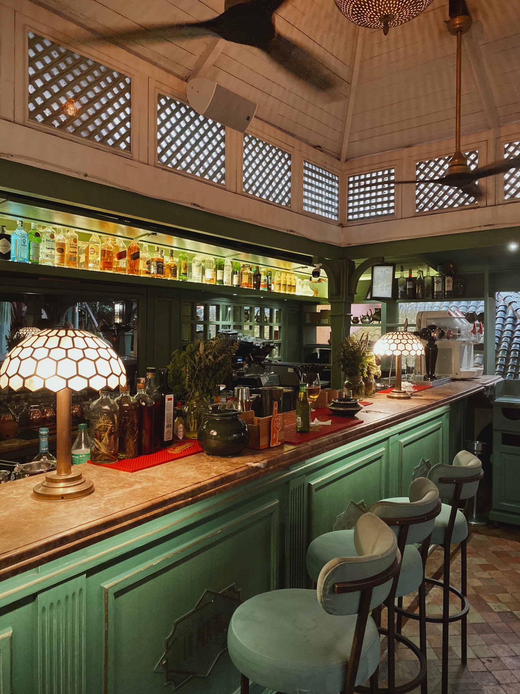 The green bar counter at La Pergola, with Tiffany-style lamps and velvet stools
