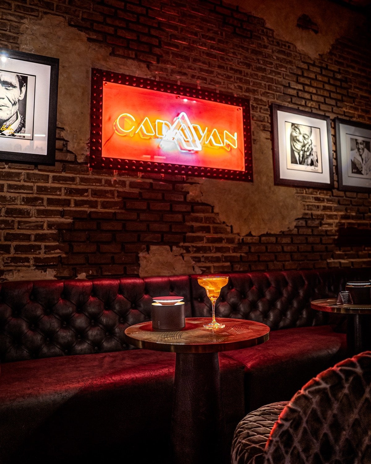 Caravan, the bar of Le Bistro Arabe: red neon sign on a brick wall above a leather banquette and a cocktail