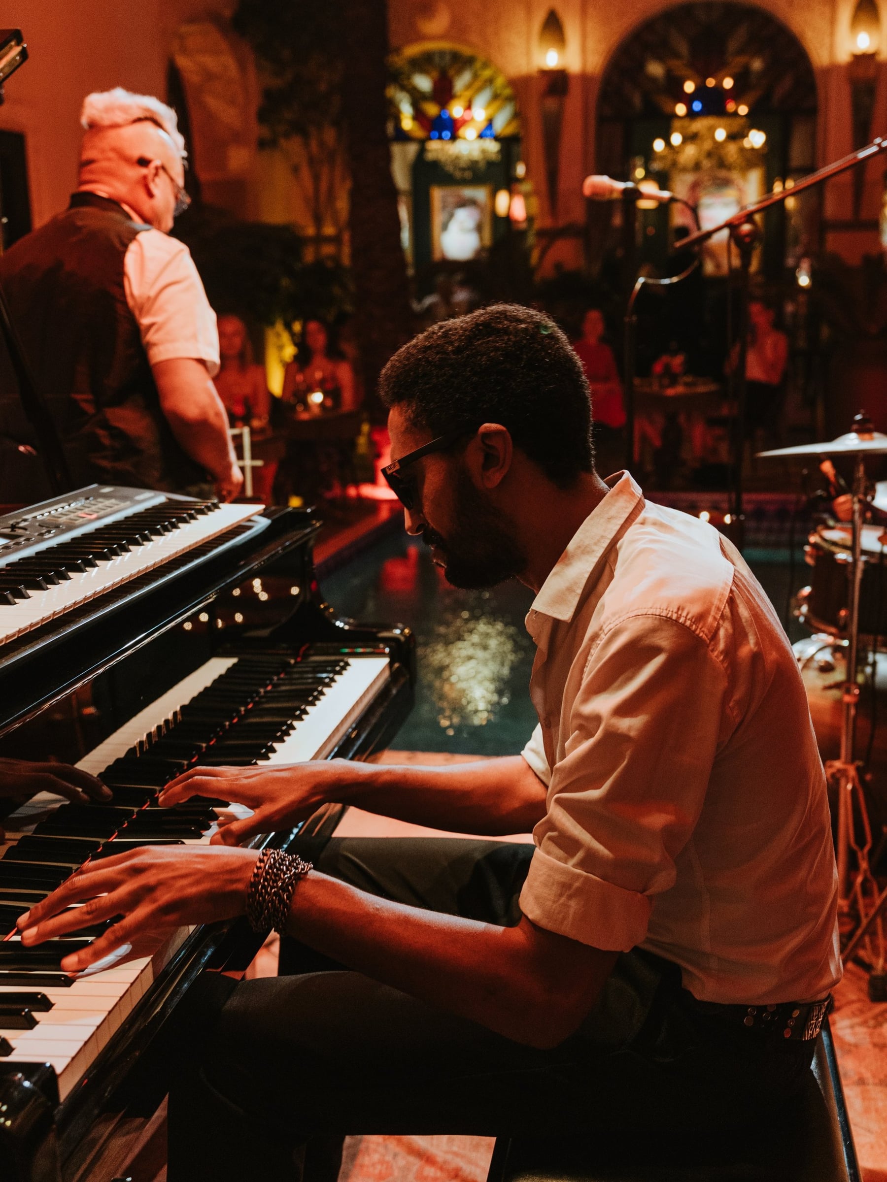 Pianist playing with the band at Le Bistro Arabe, keyboards in the foreground and warm stage light