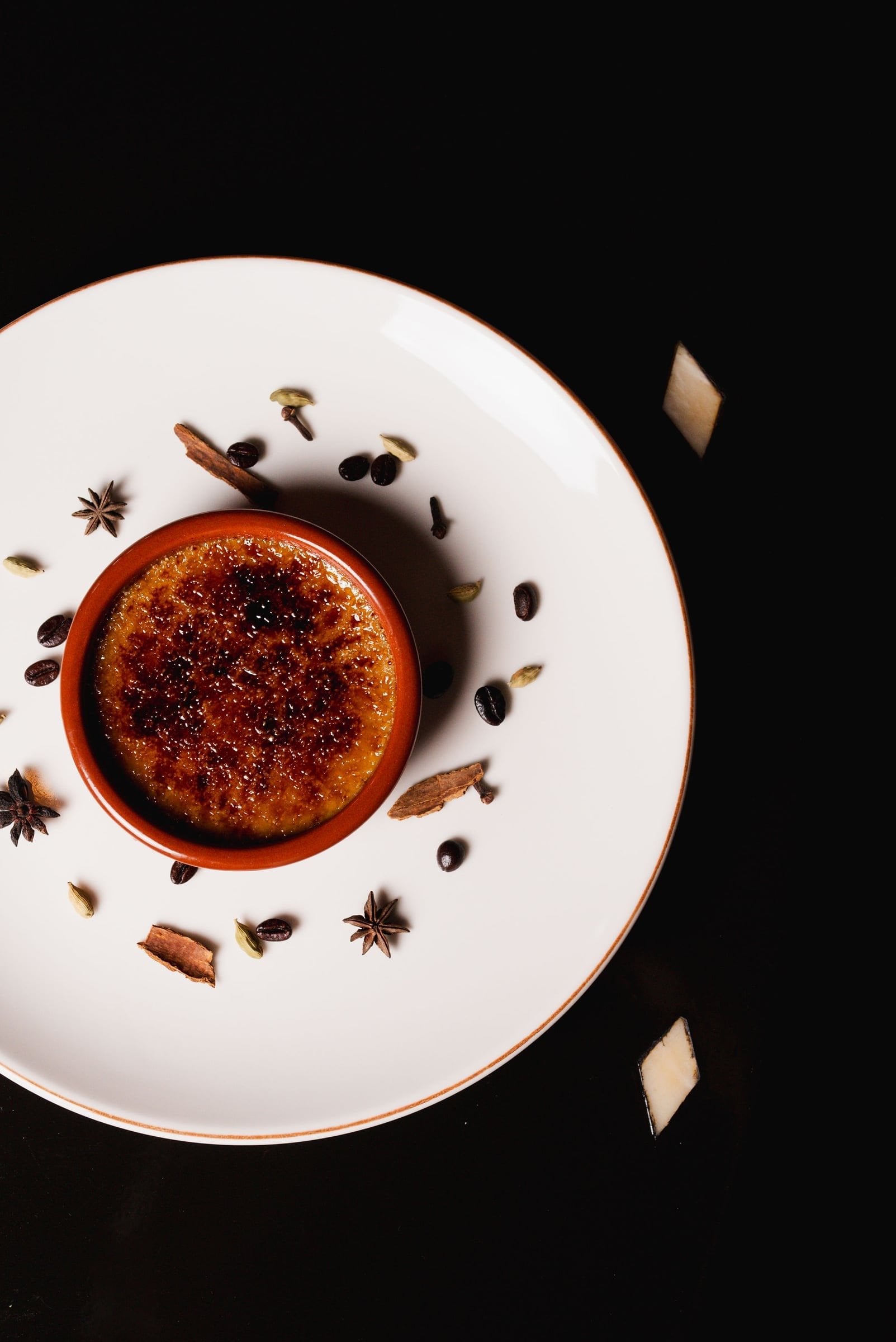Crème brûlée ringed with whole spices on a white plate at Salammbô, Les Deux Tours